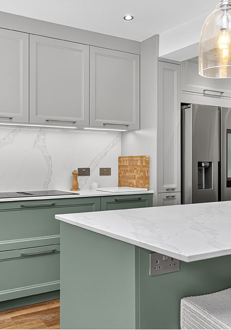 Sage green shaker kitchen with white marble worktop and integrated fridge freezer